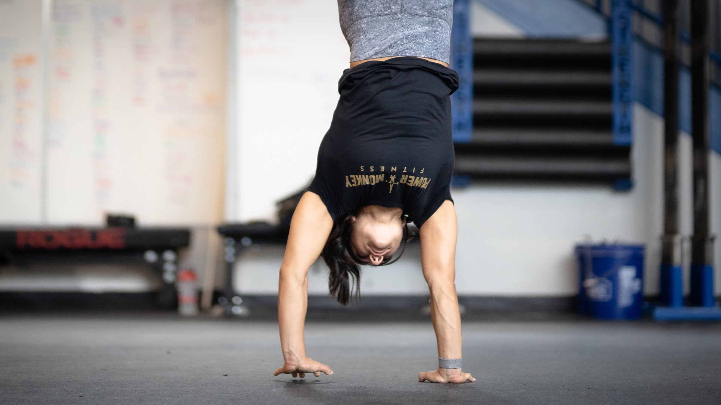 image of a woman handstand walking using the power monkey training handstand walk plan in the app