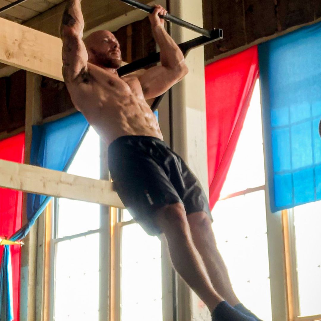 man doing a pull-up in a gym to promote the Get your First Pull-Up program in the Power Monkey Training app.