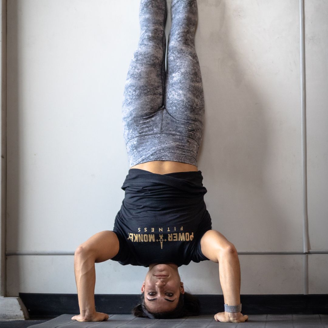 Image of a woman performing a handstand push-up to promote the handstand push-up program in the Power Monkey Training app. 