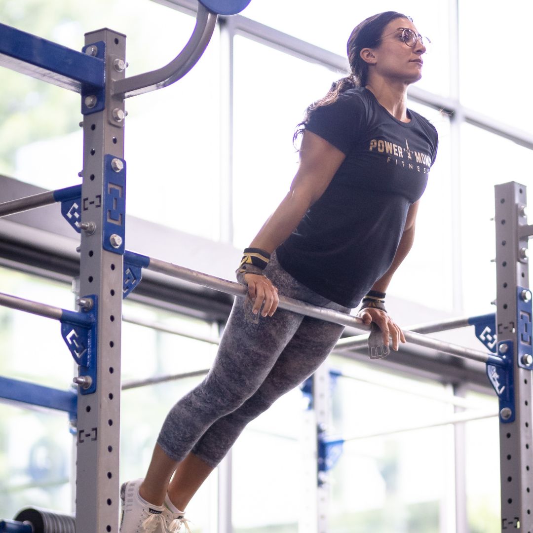 Image of a woman performing a bar muscle-up to promote the kipping bar muscle up program in the Power Monkey Training app. 