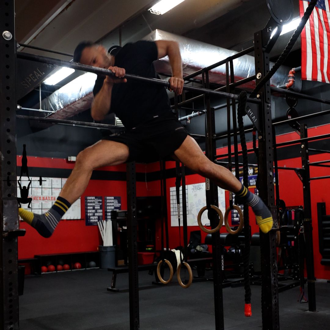 Image of a man performing a bad bar muscle-up to promote the bar muscle up chicken wing cure program in the Power Monkey Training app. 