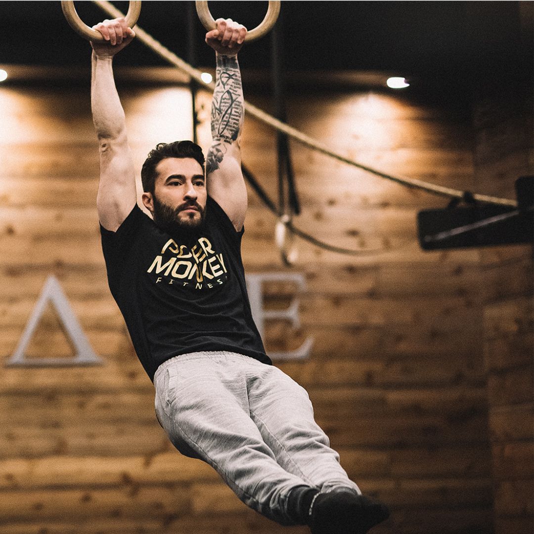 Image of a man performing a strict ring muscle-up to promote the strict ring muscle up program in the Power Monkey Training app. 