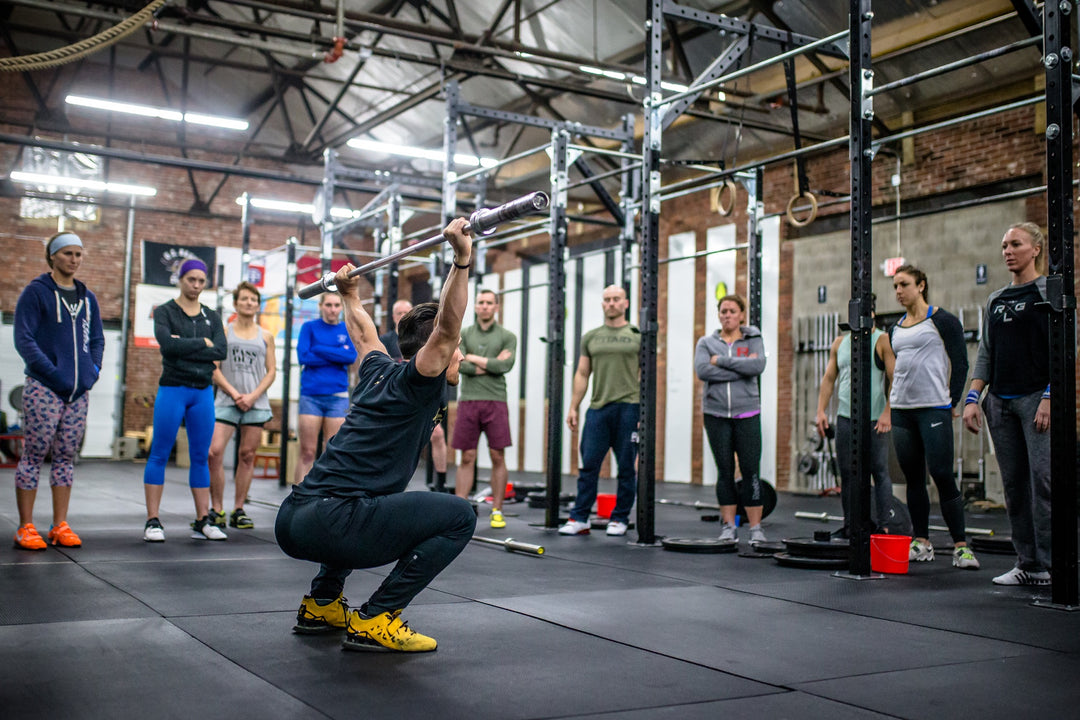 Photo of Mike Cerbus performing a snatch in front of a group of people at a Power Monkey Course.