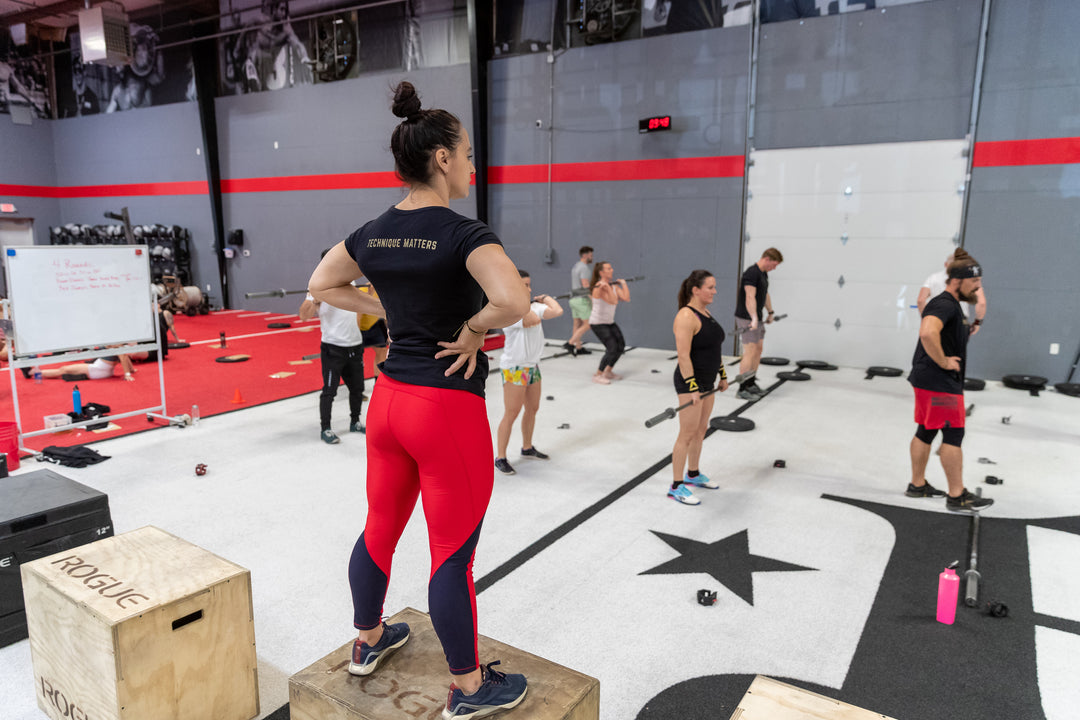 Photo of Power Monkey Coach Vanessa McCoy-Nelson overlooking campers at CrossFit Mayhem during a weightlifting session