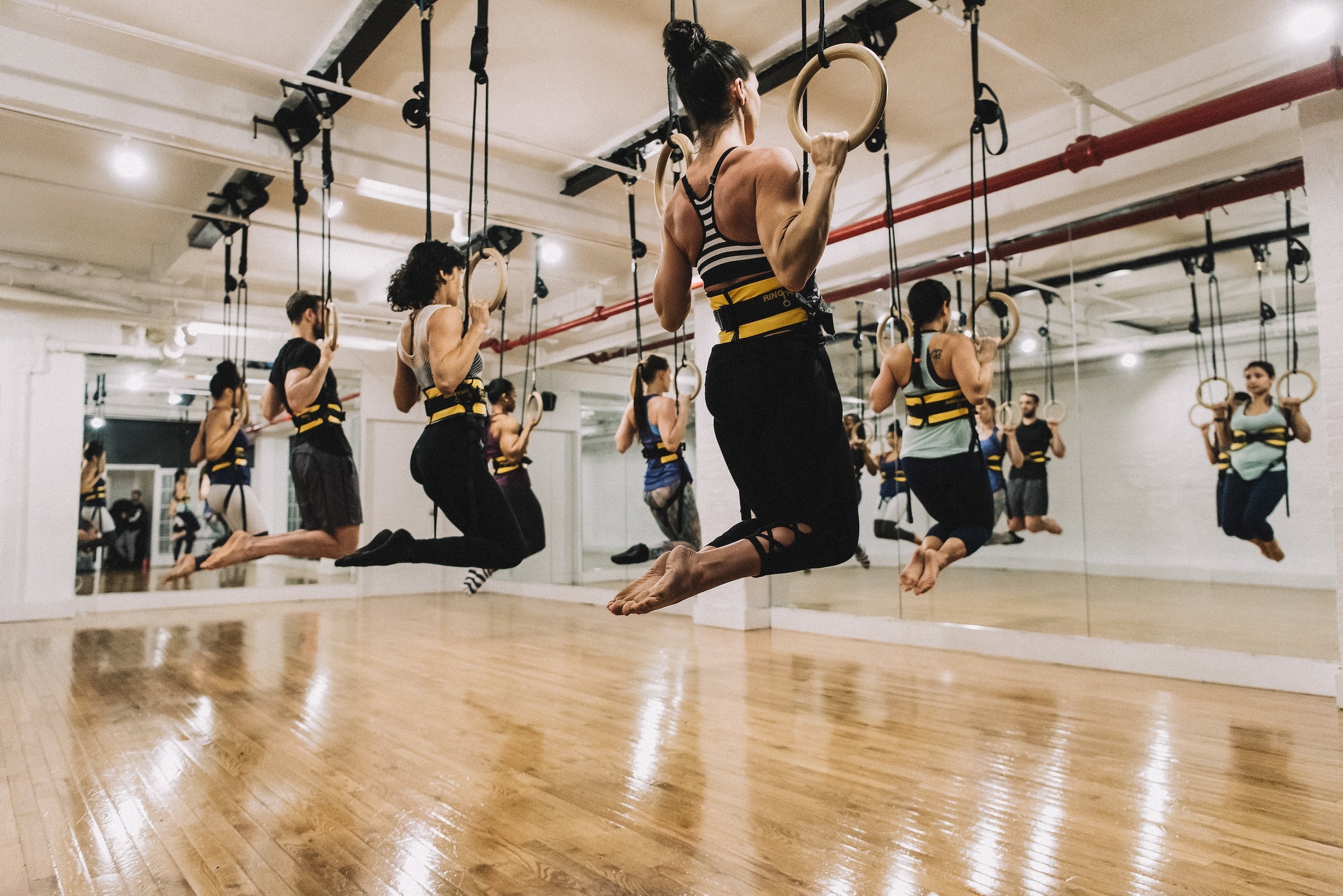 Group of people in the Power Monkey Ring Thing taking a workout class in a studio