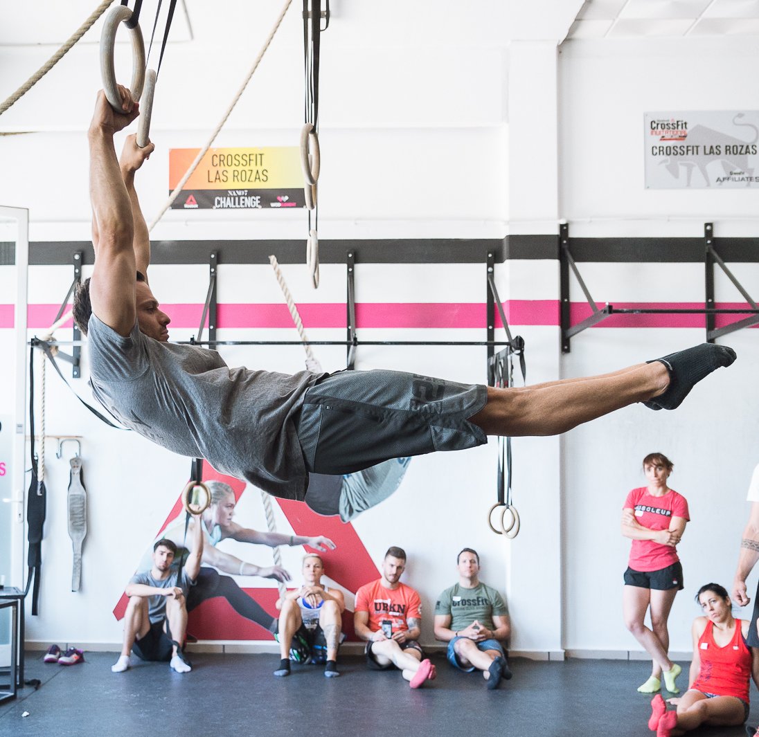 dave durante performing swinging on gymnastics rings for a power monkey fitness course