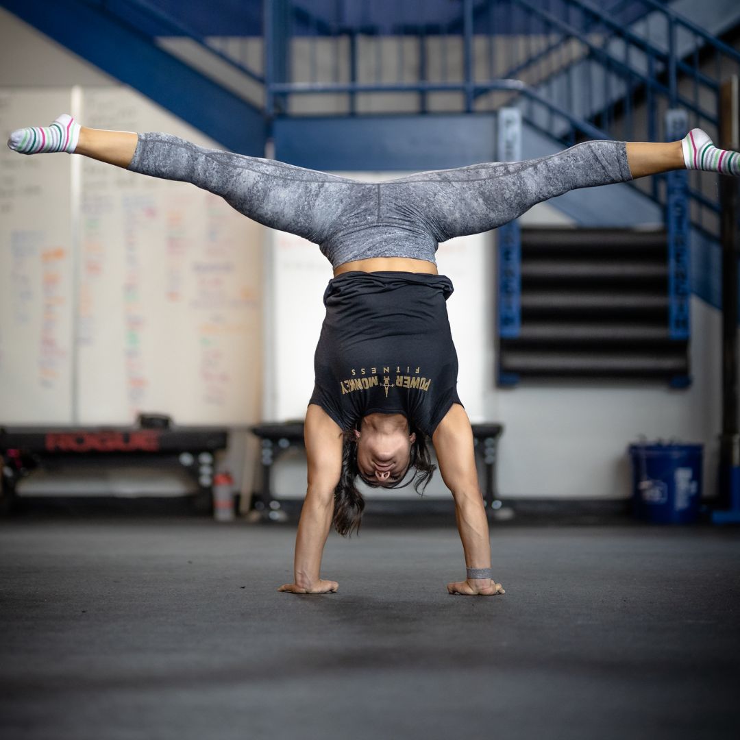Image of a woman performing a Press to handstand to promote the Press to handstand program in the Power Monkey Training app. 